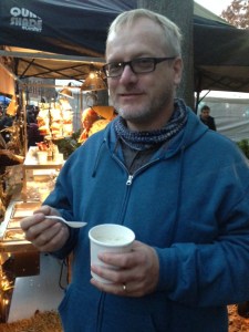 Andrew eating clam chowder from a booth run by three older ladies who danced to the music as they served our soup.